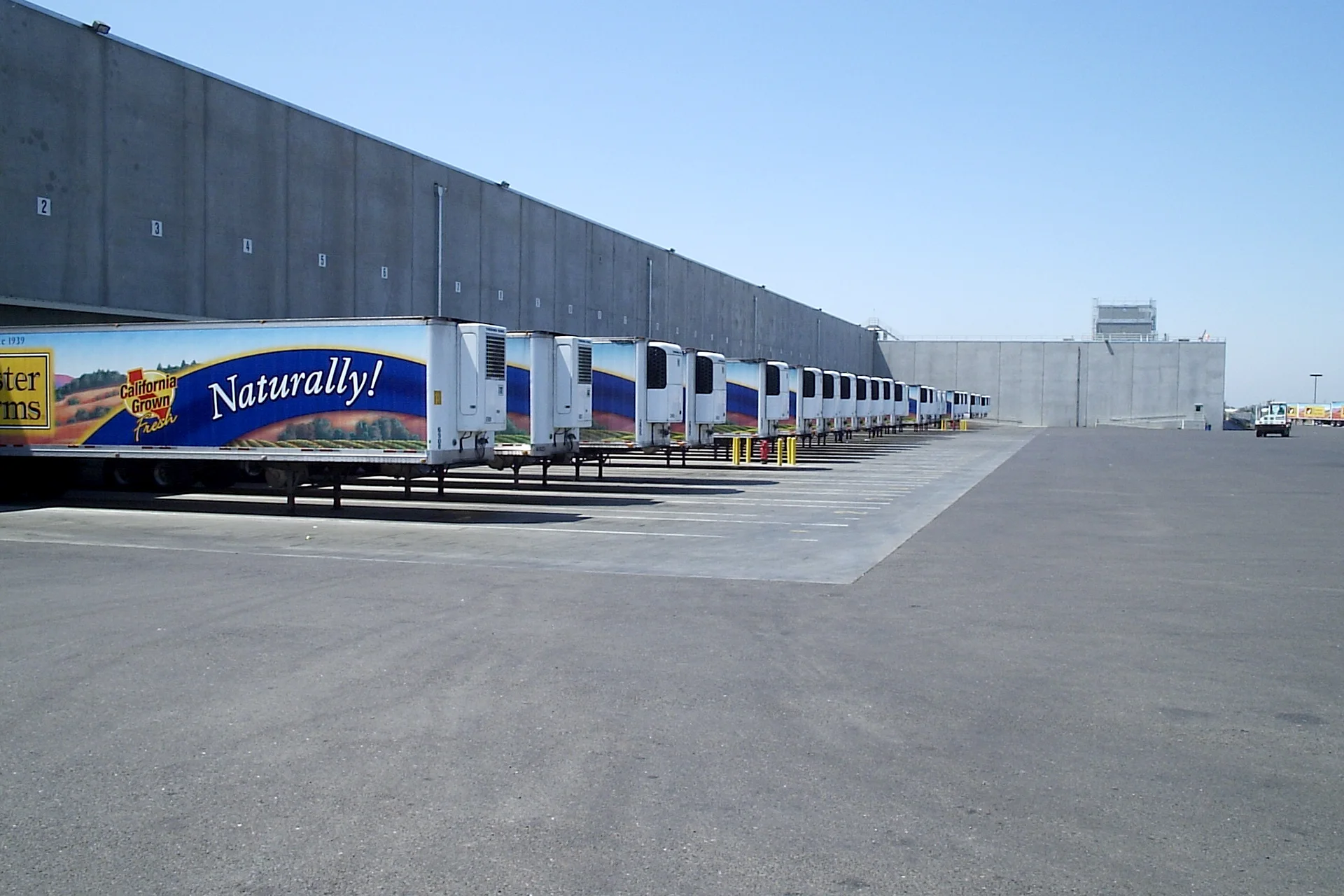 Loading dock area at the Foster Farms National Chicken Distribution Center with refrigerated trailers parked along the warehouse distribution facility.