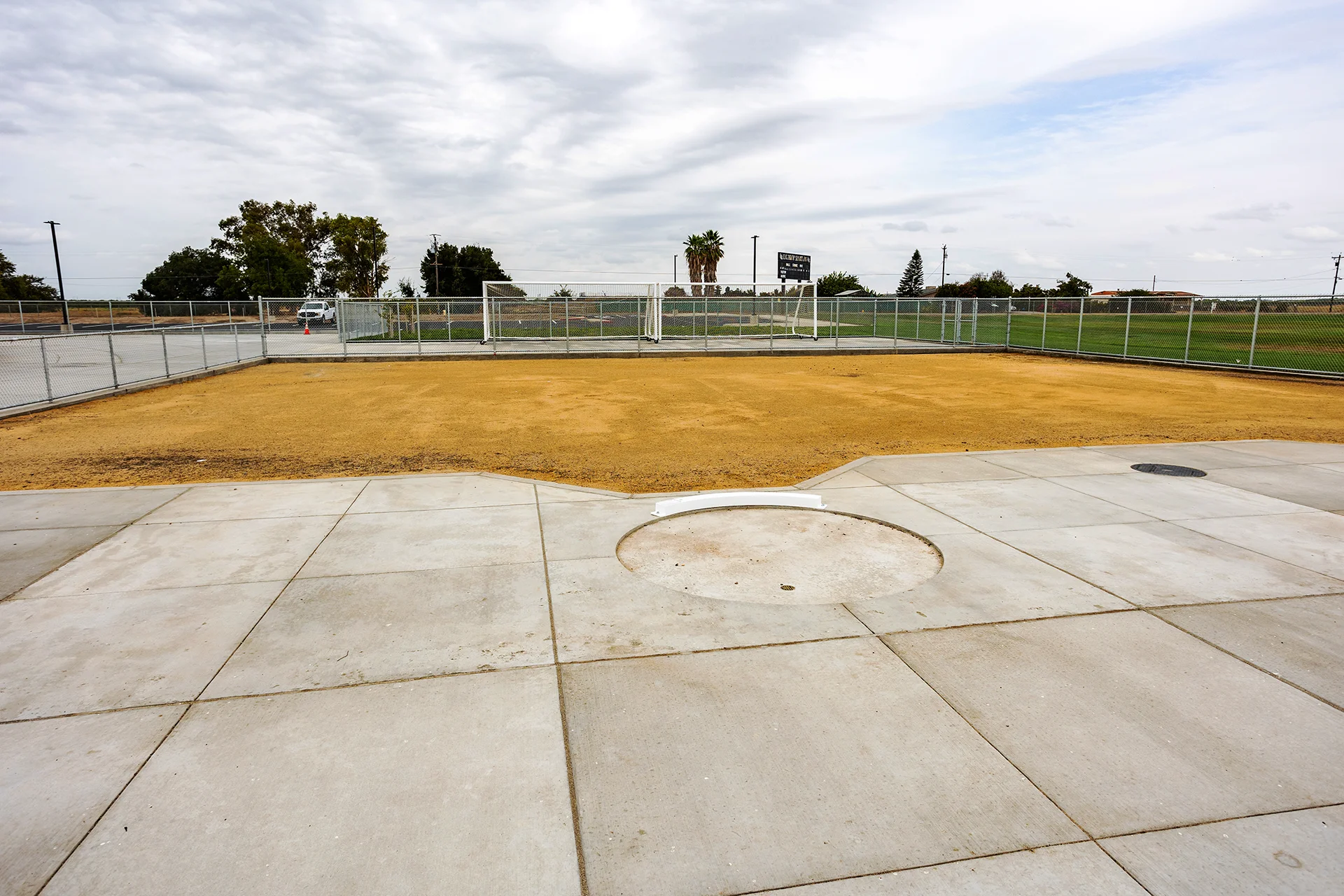 Lathrop High School shot put throwing circle and landing area enclosed by safety fencing near the athletic fields and track complex.