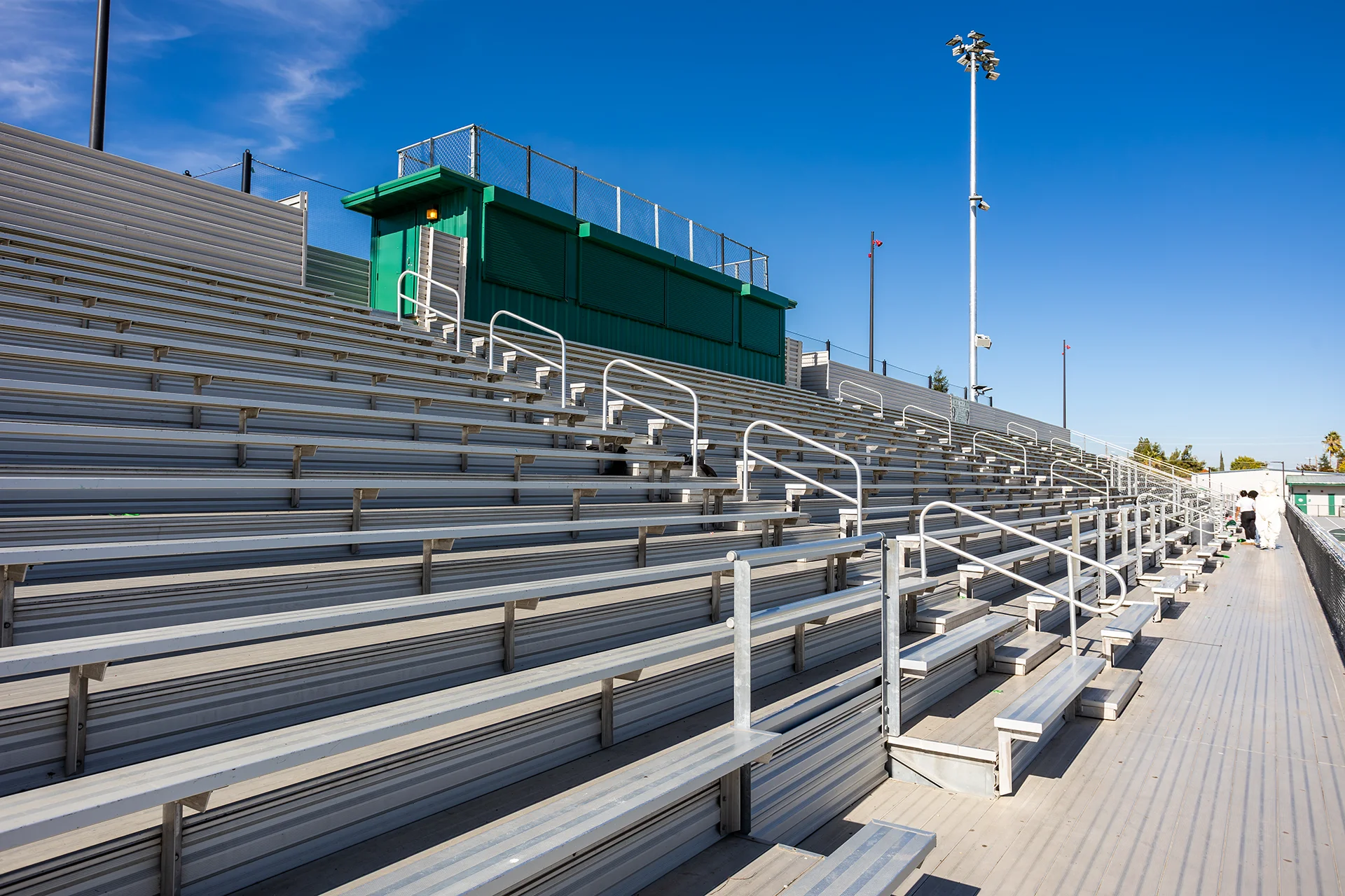 Renovated aluminum stadium bleachers with accessible seating areas and press facilities at Manteca High School.