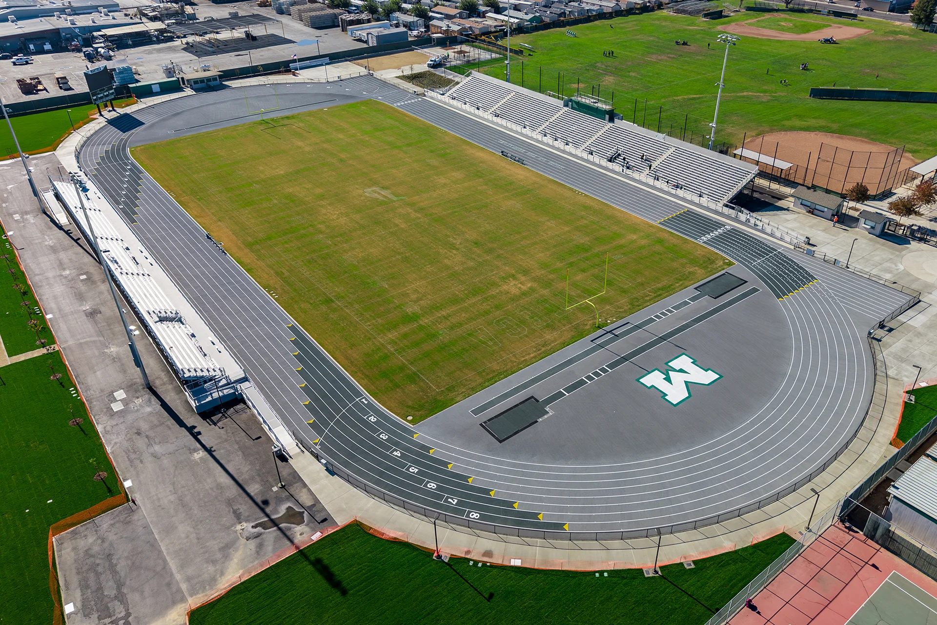 Aerial view of Manteca High School’s renovated football stadium, running track, bleachers, and athletic facilities surrounding the field.