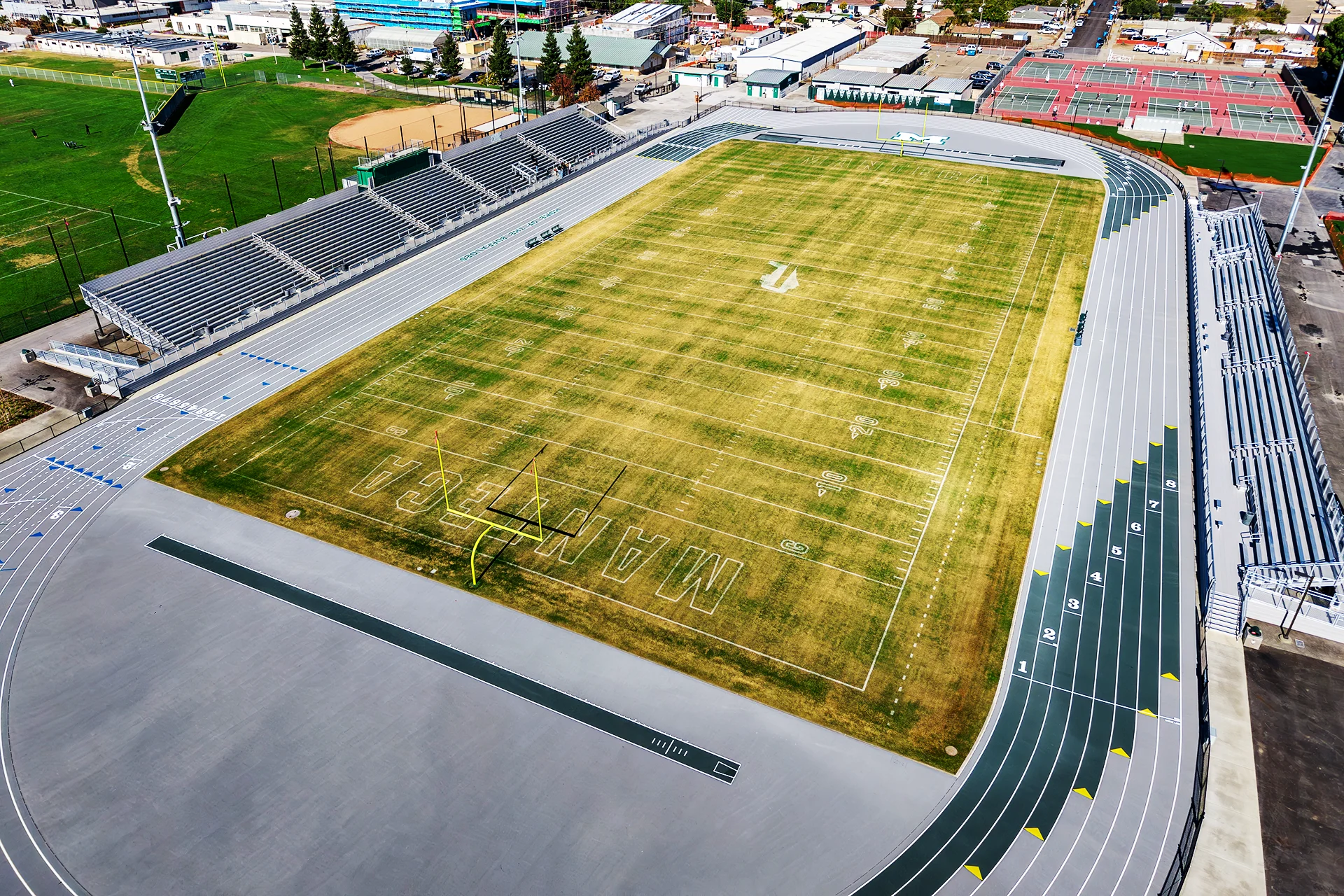 Aerial view of Manteca High School’s renovated football field, running track, stadium seating, and surrounding athletic facilities.