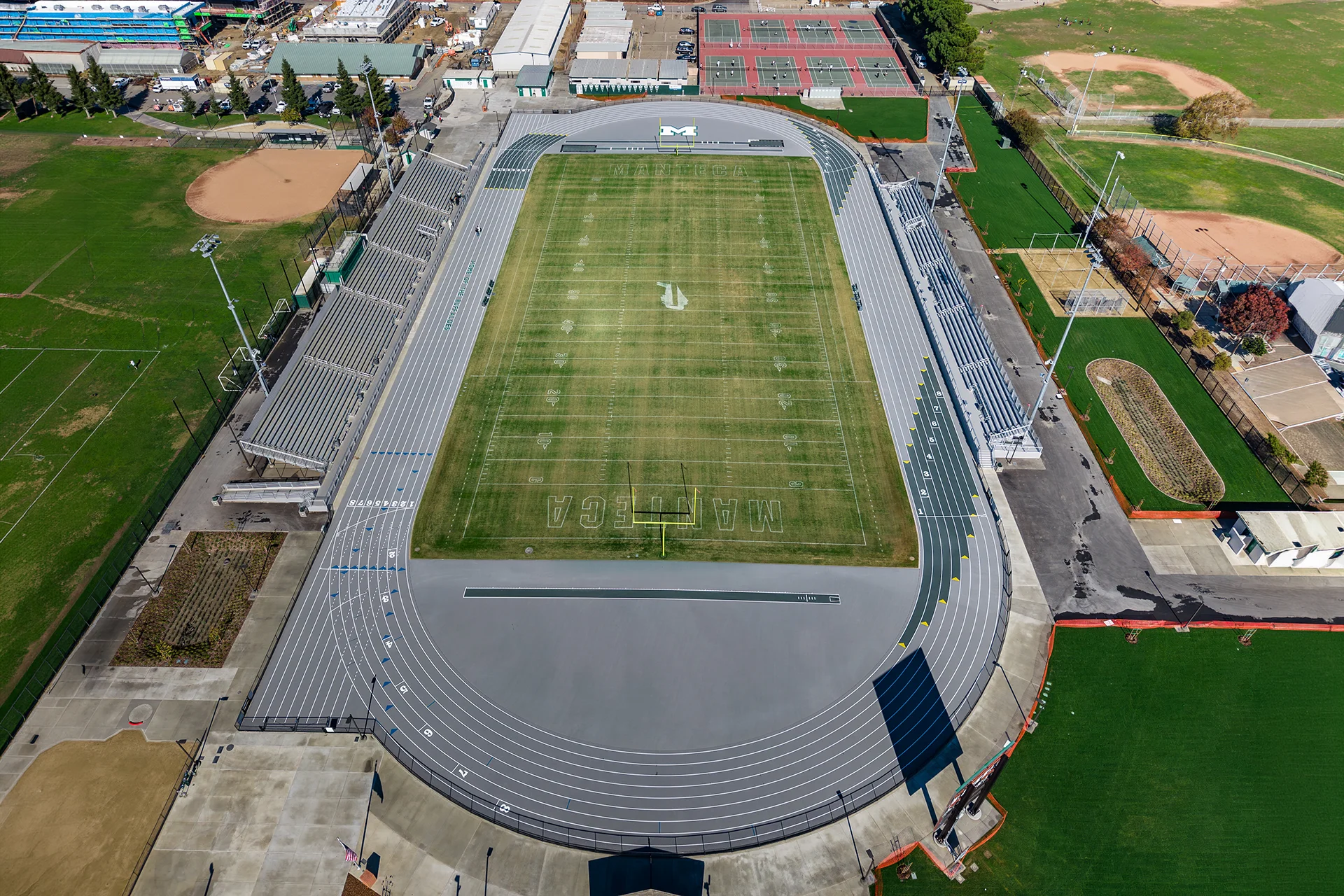 Aerial view of Manteca High School’s renovated track, football field, stadium seating, and surrounding athletic facilities.