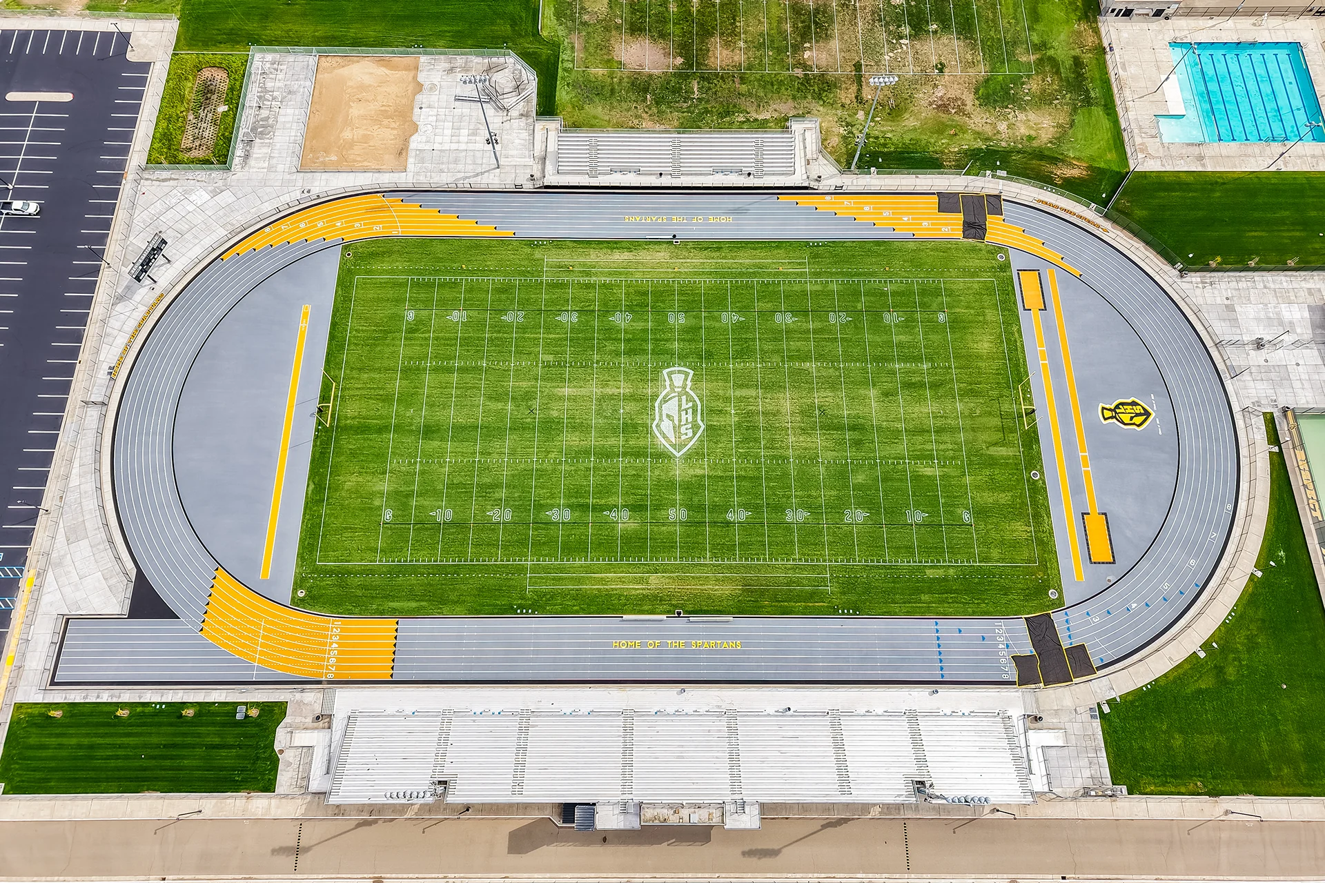 A high, top-down drone photograph showing the entire football field and surrounding running track at Lathrop High School.