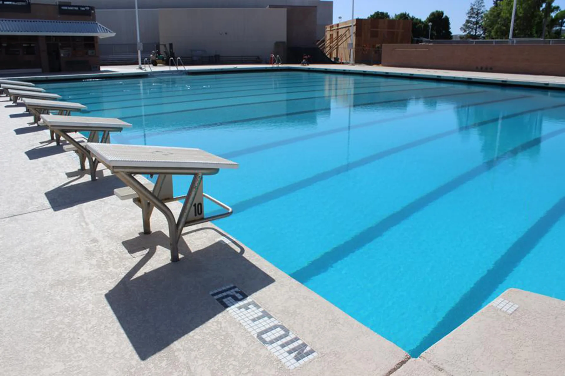 Starting blocks line the edge of the competition swimming pool at Pitman High School’s aquatics facility.