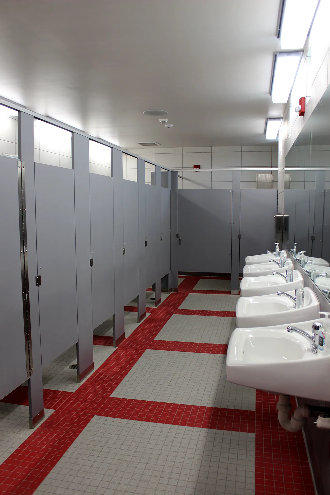 Clean and modern restroom interior at Ripon High School’s athletic complex featuring private stalls, sinks, and durable tile finishes.
