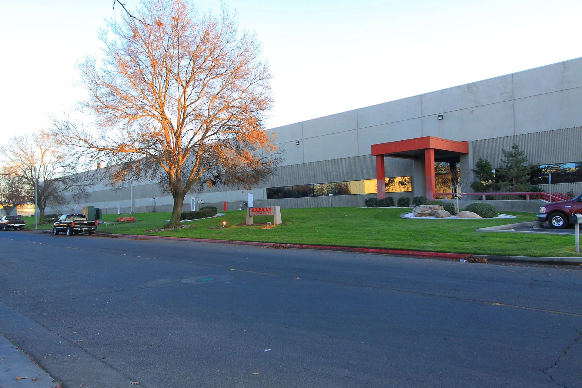 Exterior view of the Scholle Packaging corporate headquarters featuring the main entrance, landscaped grounds, company monument sign, and industrial facility.
