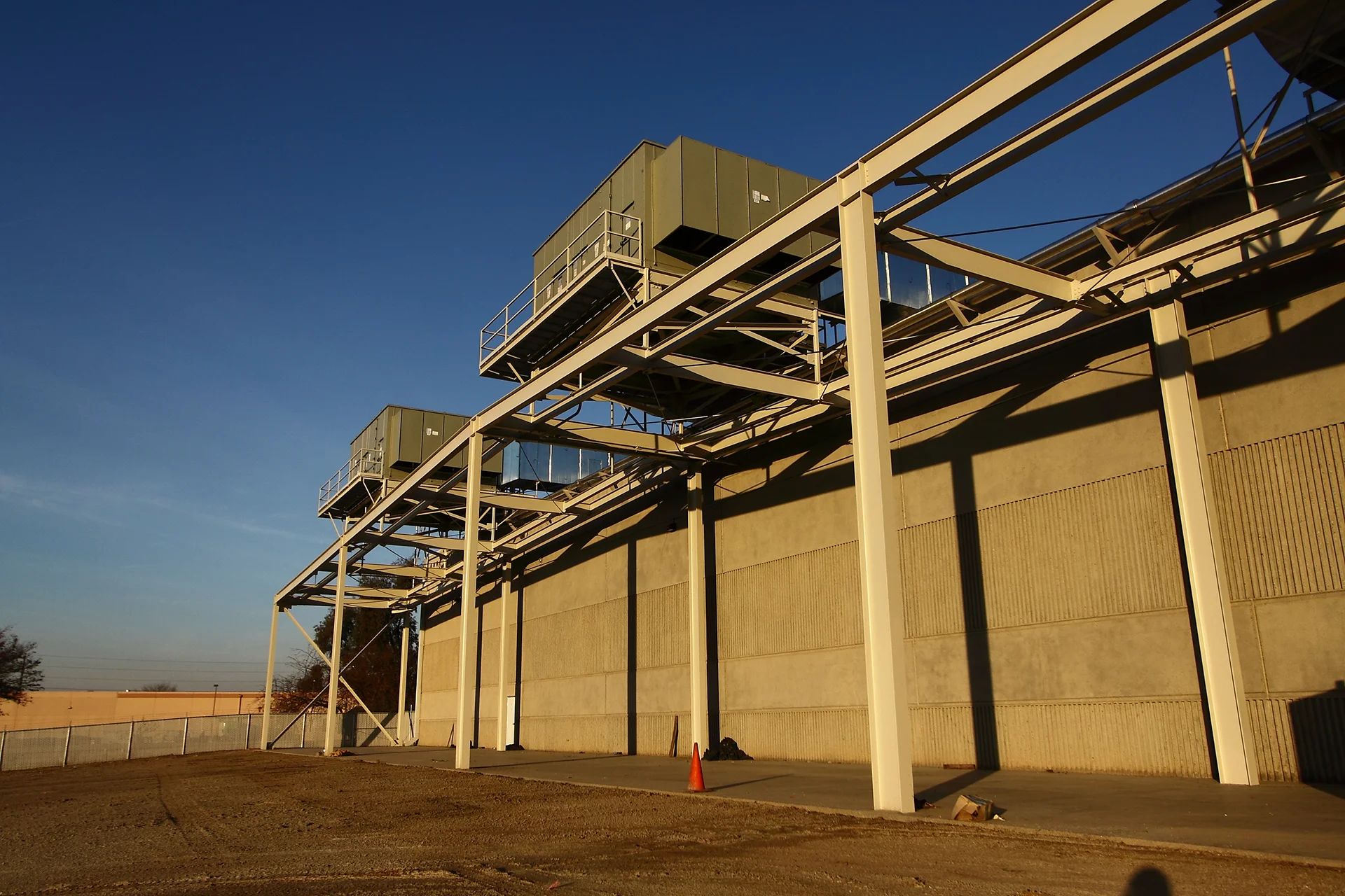 Exterior view of Scholle Packaging’s industrial building featuring elevated mechanical equipment, structural steel supports, and rooftop HVAC infrastructure.
