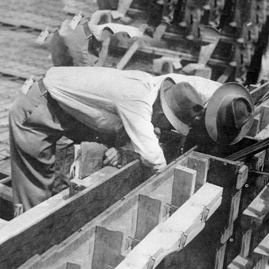 Vintage Carpentry Crew Installing Wood Foundation Forms Historic black-and-white snapshot of construction workers in fedora hats setting up wood formwork and timber framing for concrete foundations on a mid-century California commercial jobsite.