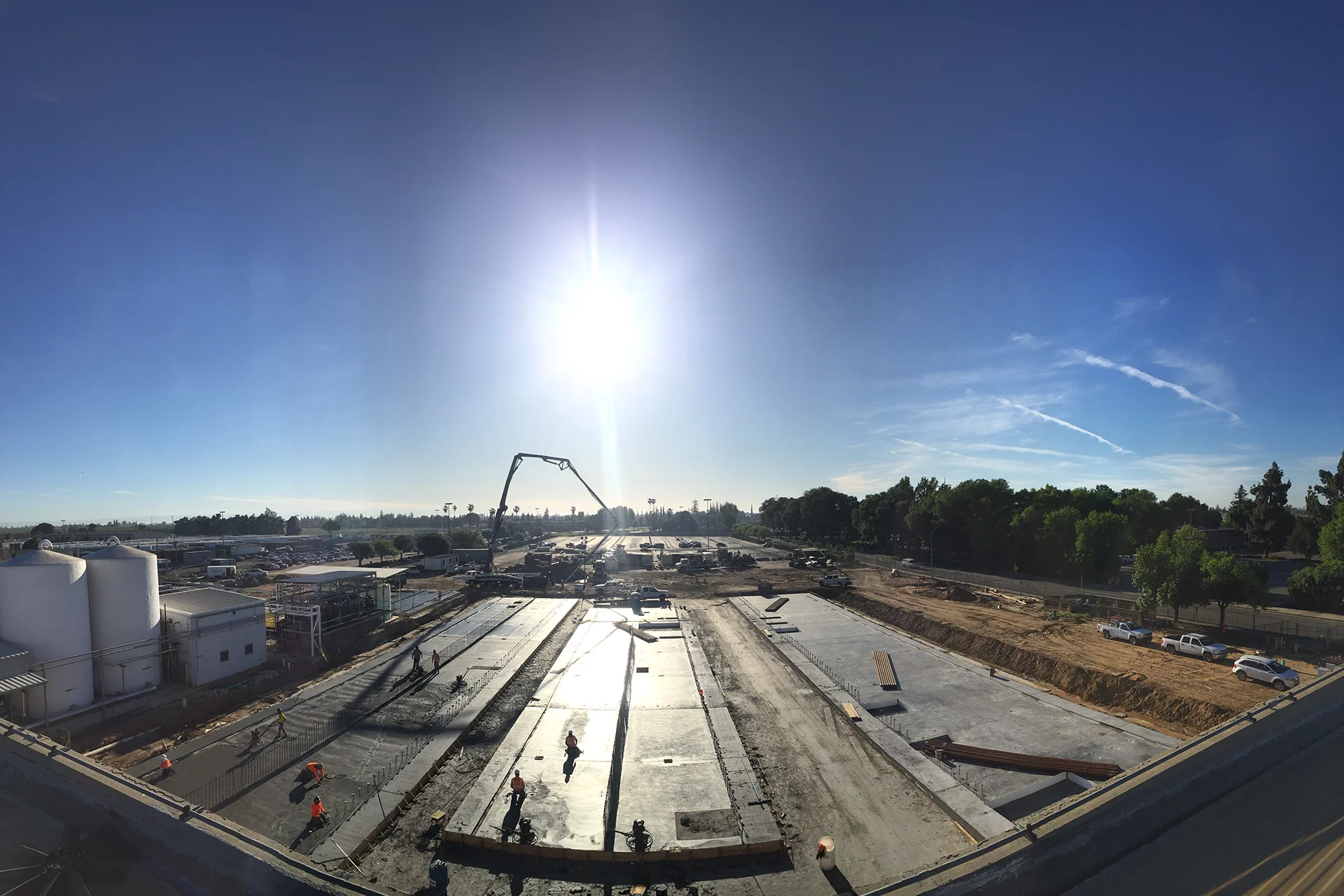Construction crews place concrete foundations during the Foster Farms Livingston Plant Expansion, with pump trucks, workers, and active industrial site development underway.