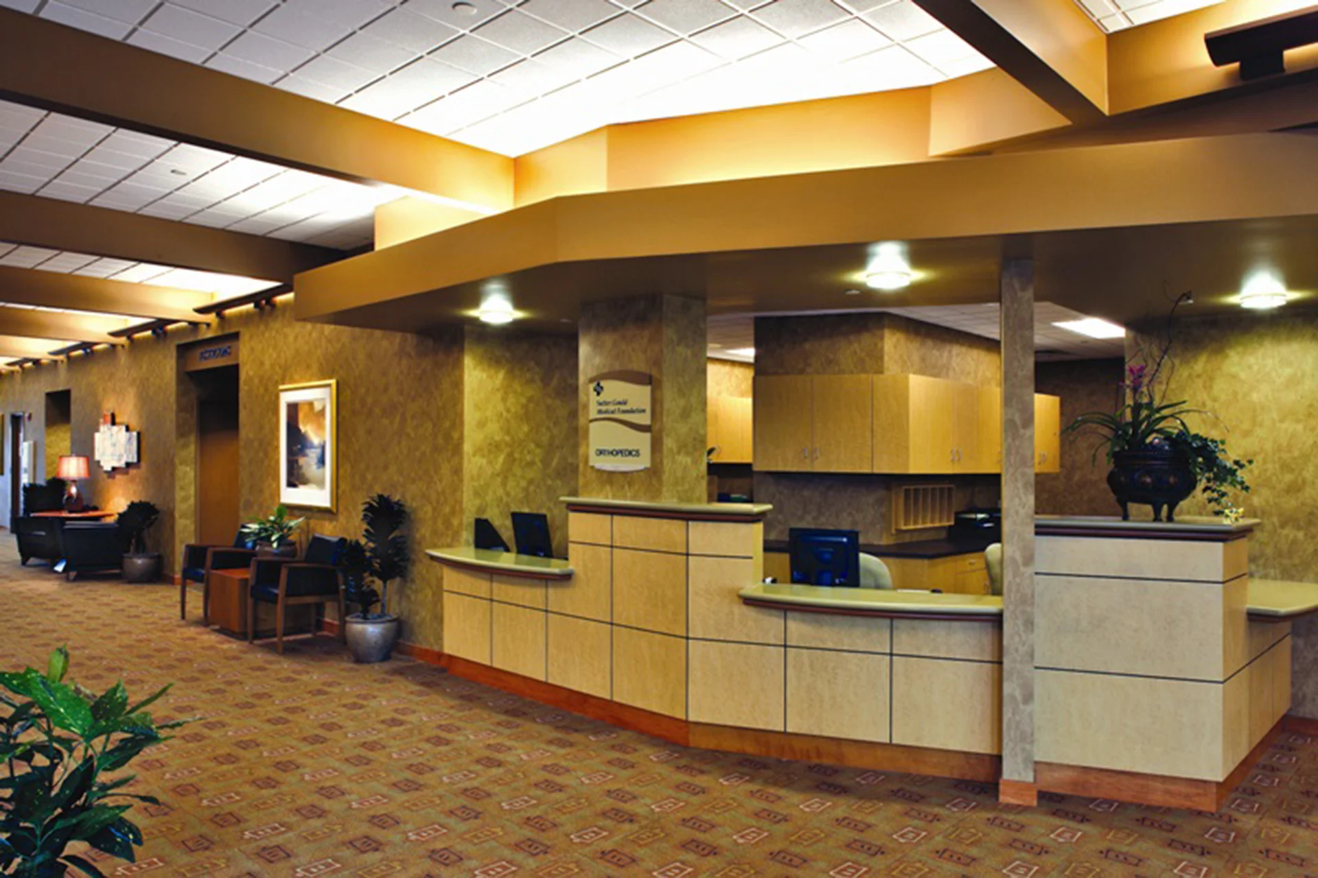 Patient reception area inside the Sutter Gould Briggsmore Specialty Center featuring the orthopedic check-in desk, welcoming lobby seating, wayfinding signage, and contemporary healthcare interior design.