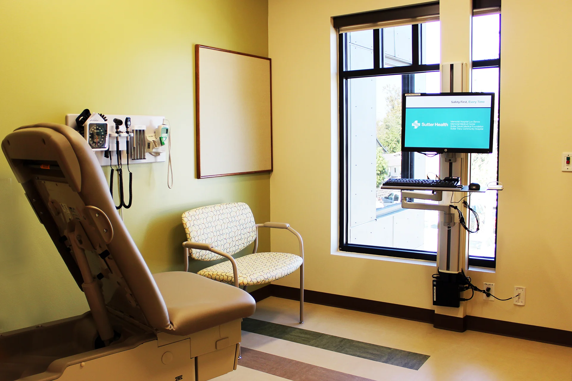 Patient exam room inside the Sutter Gould Tracy Medical Office Building featuring a medical examination table, diagnostic equipment, electronic health record workstation, and a modern clinical care environment.