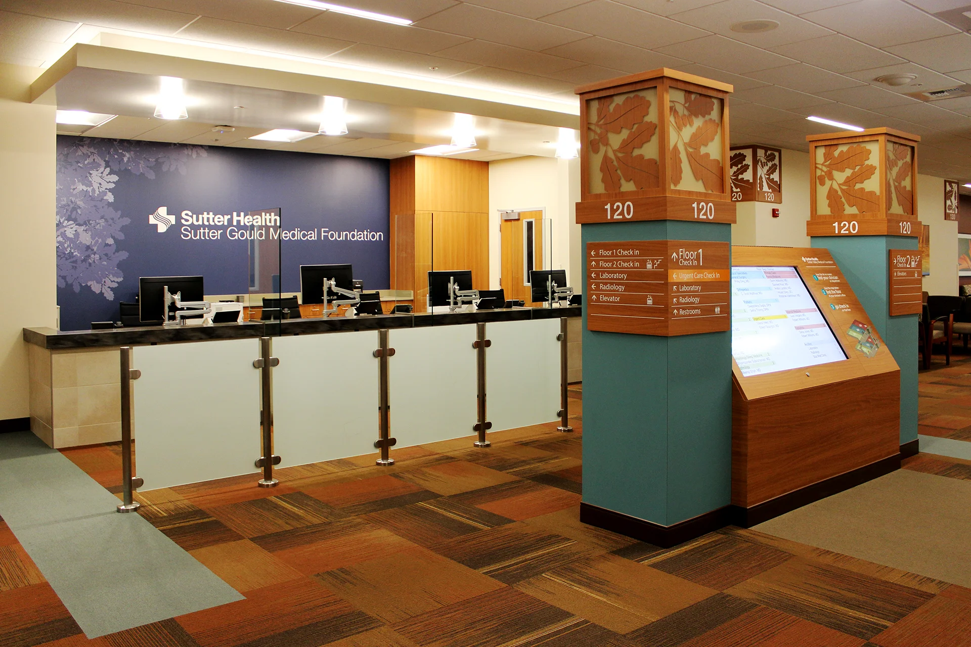 Patient check-in and reception area inside the Sutter Gould Tracy Medical Office Building featuring registration counters, digital wayfinding kiosk, directory signage, and a modern, accessible healthcare lobby.