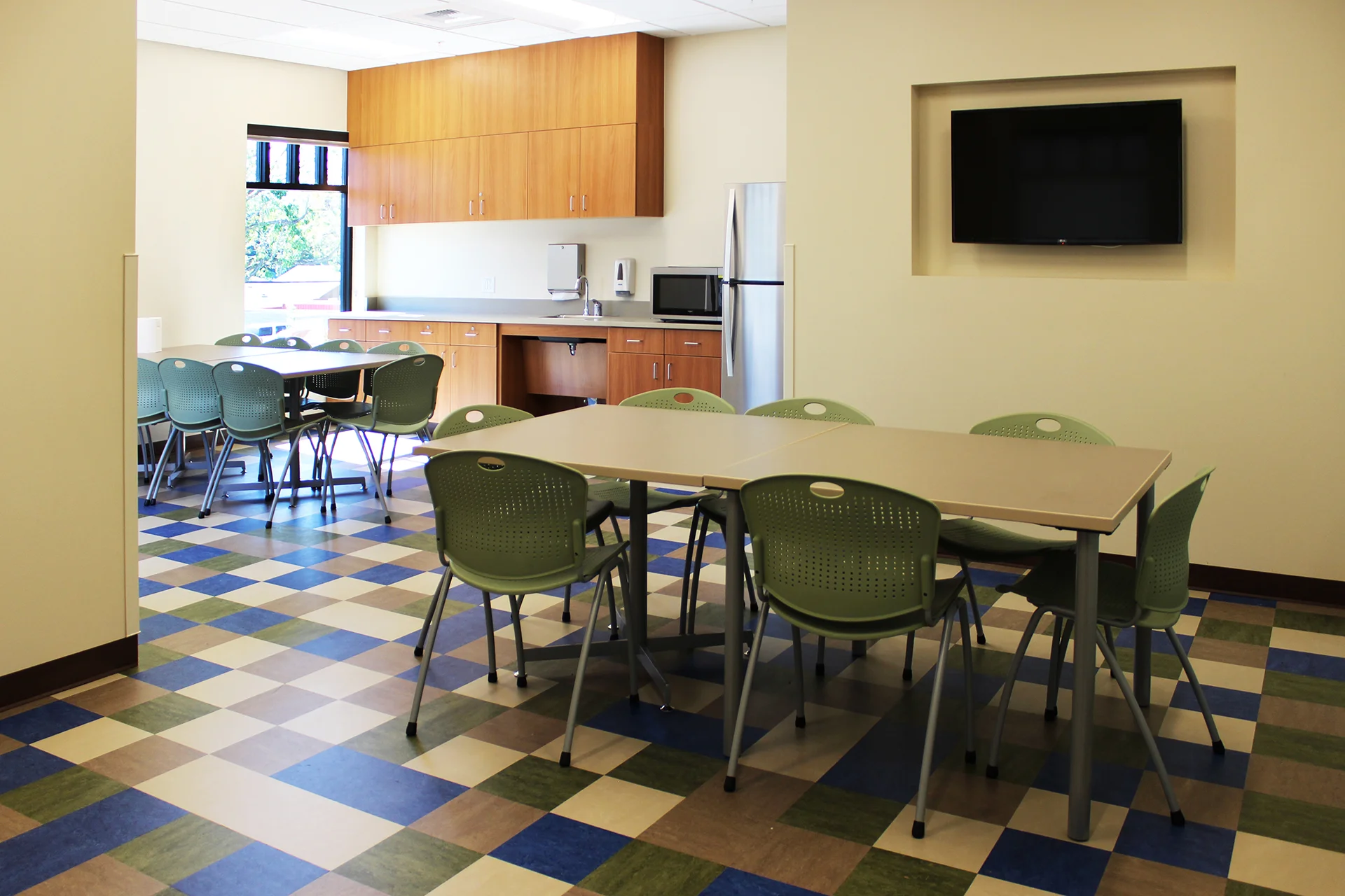 Staff break room inside the Sutter Gould Tracy Medical Office Building featuring a kitchenette, dining tables, seating, television, and a comfortable space for healthcare staff collaboration and breaks.