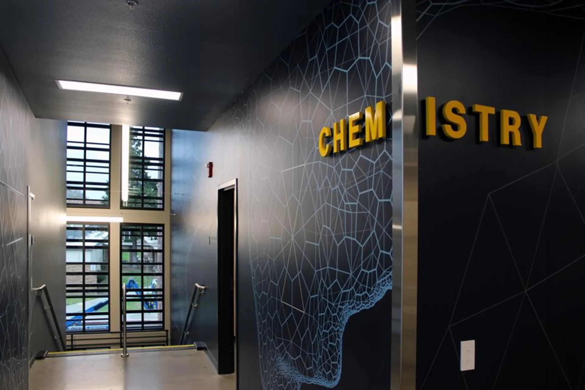 Interior corridor of the Turlock High School Science Building featuring the Chemistry wing entrance, modern wayfinding signage, geometric wall graphics, and contemporary educational design.