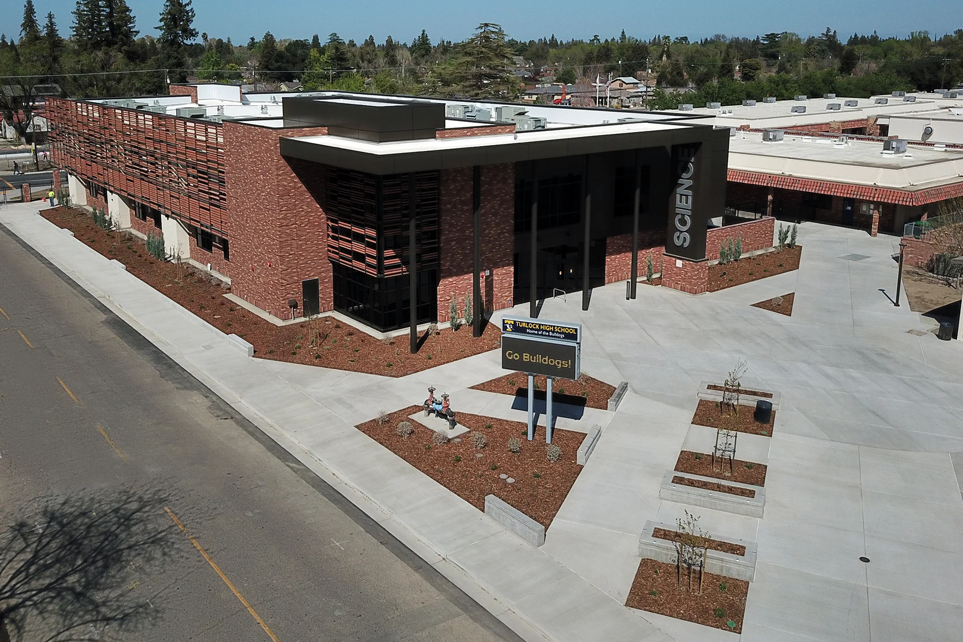 Aerial view of the Turlock High School Science Building highlighting the main entrance, contemporary brick and metal façade, landscaped campus plaza, and modern STEM education facilities.
