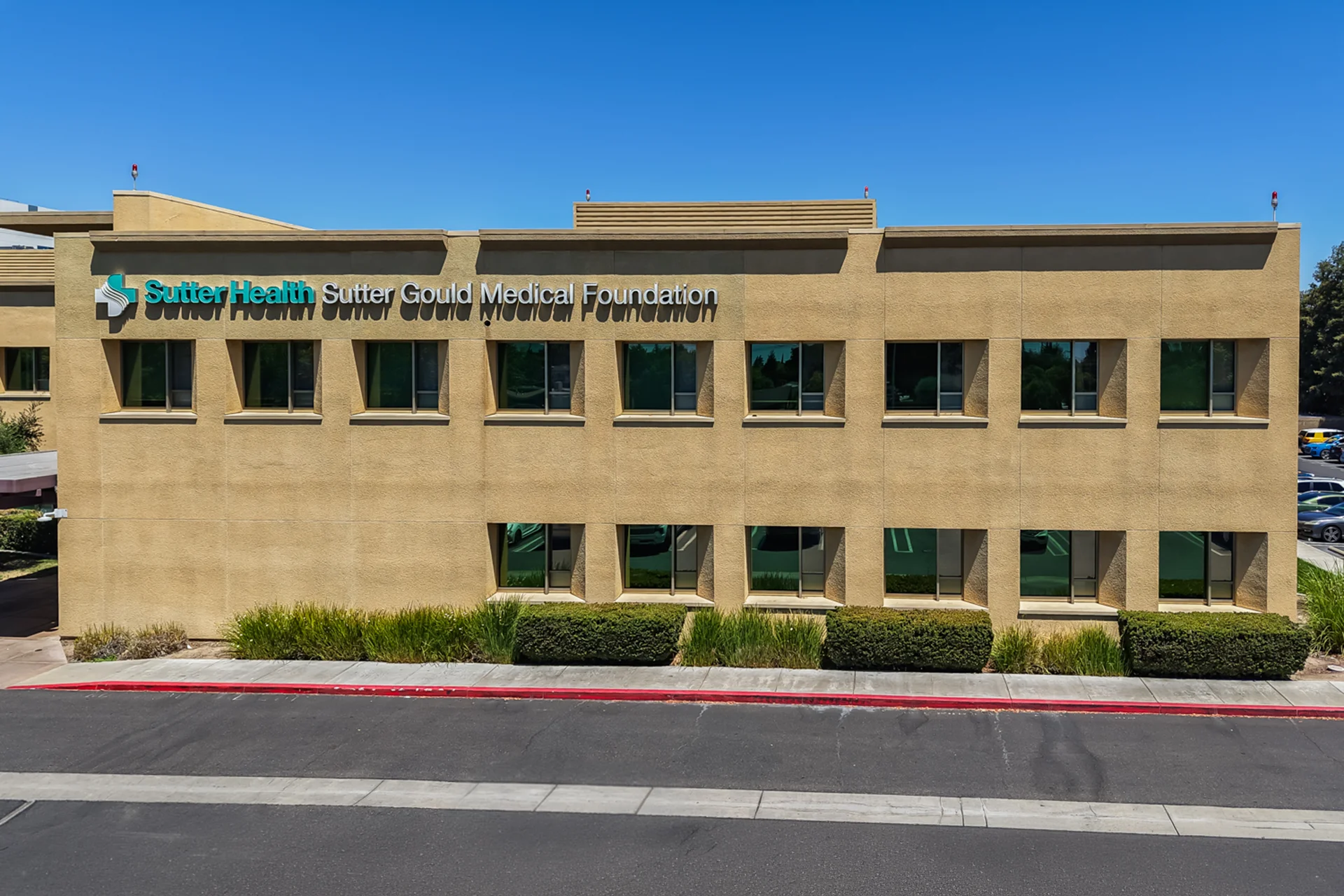 Exterior facade of the Sutter Gould Briggsmore Specialty Center displaying Sutter Health and Sutter Gould Medical Foundation signage, contemporary healthcare architecture, and landscaped grounds in Modesto, California.