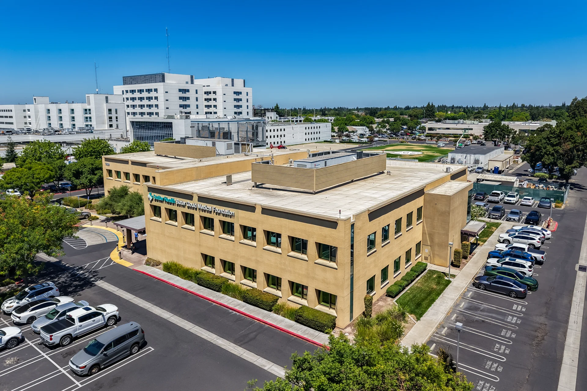 Aerial view of the Sutter Gould Briggsmore Specialty Center featuring the specialty medical office building, patient parking, covered entrance, and adjacent Memorial Medical Center campus in Modesto, California.