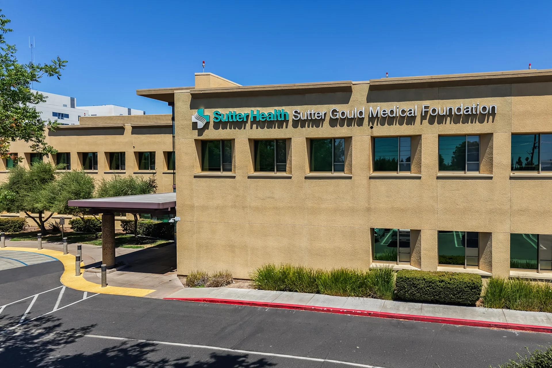 Exterior view of the Sutter Gould Briggsmore Specialty Center featuring Sutter Health and Sutter Gould Medical Foundation signage, the covered patient entrance, landscaped grounds, and modern specialty healthcare architecture in Modesto, California.
