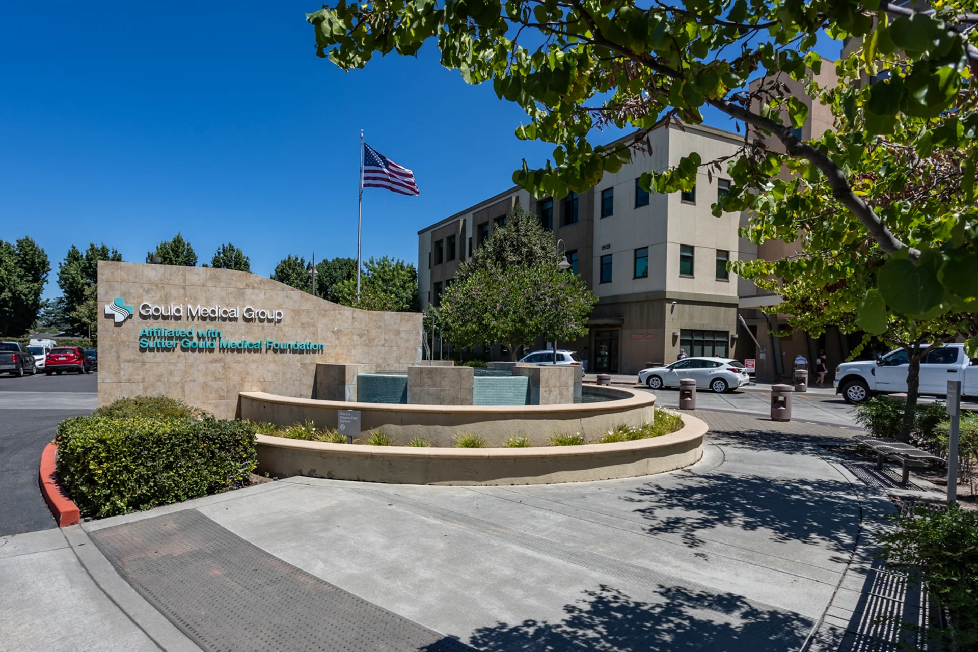 Exterior view of the Sutter Gould Coffee Road Medical Office Building featuring the Gould Medical Group monument sign, landscaped entrance plaza, fountain, and modern healthcare campus in Modesto, California.