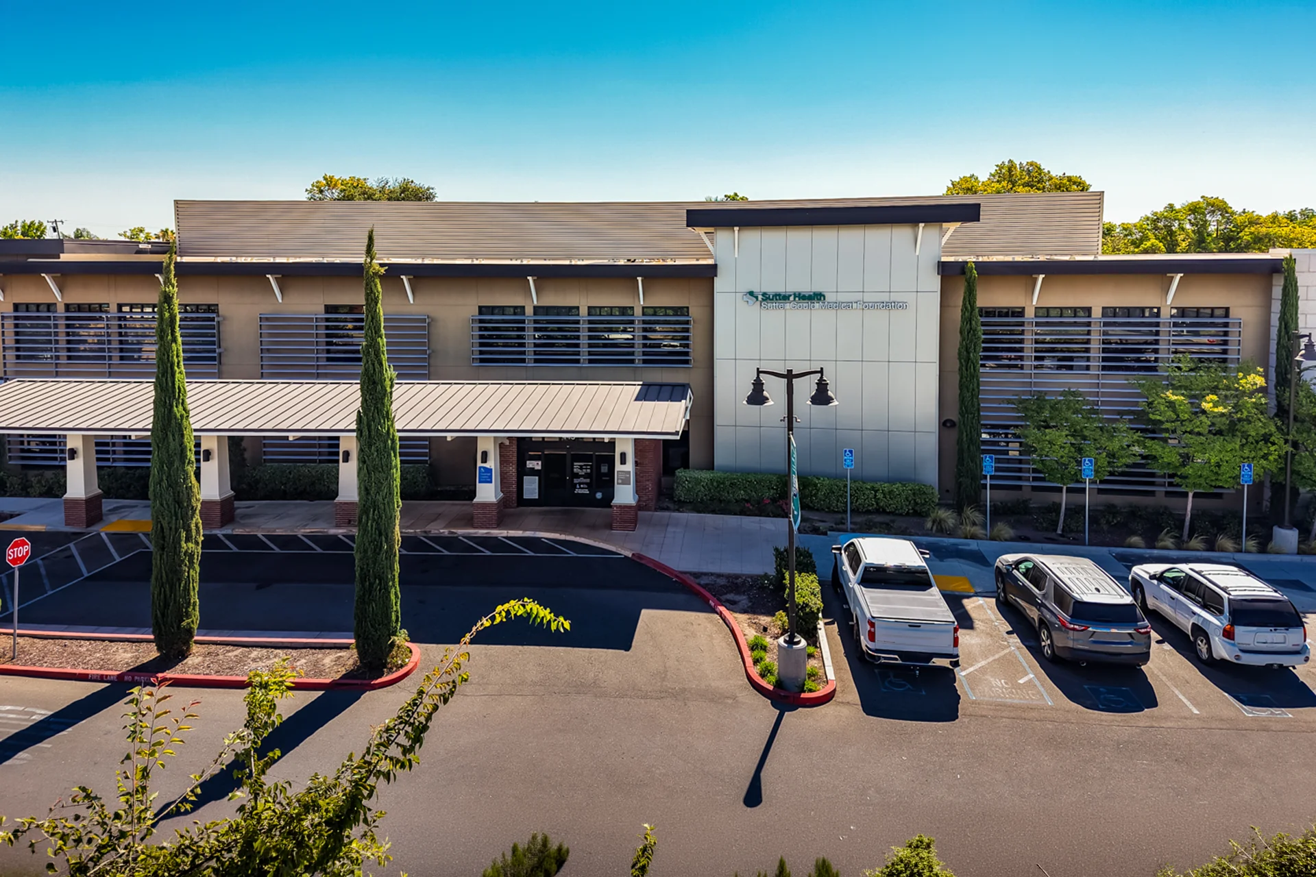 Front exterior of the Sutter Gould Tracy Medical Office Building featuring the covered patient entrance, accessible parking, Sutter Health and Sutter Gould Medical Foundation signage, and modern outpatient healthcare architecture in Tracy, California.