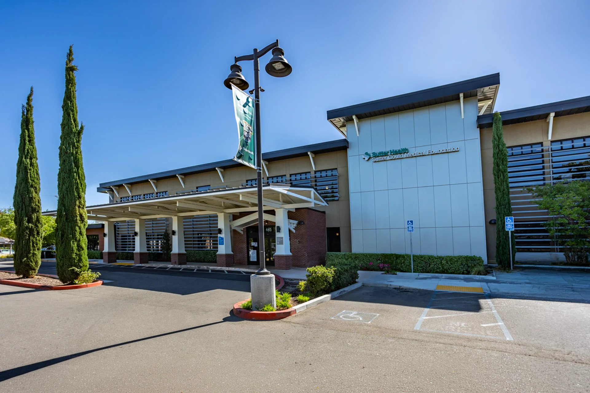 Front entrance of the Sutter Gould Tracy Medical Office Building featuring the covered patient drop-off, accessible parking, landscaped grounds, and modern outpatient healthcare facility in Tracy, California.