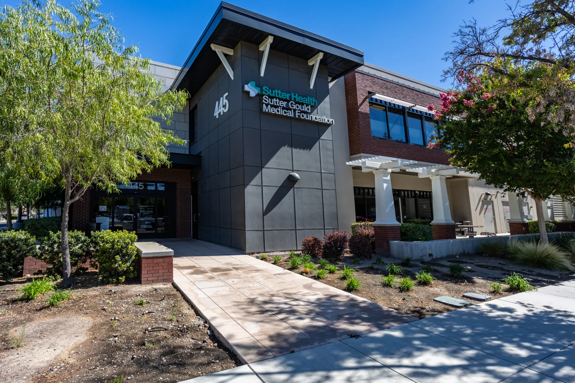 Exterior view of the Sutter Gould Tracy Medical Office Building featuring the primary patient entrance, Sutter Health and Sutter Gould Medical Foundation signage, landscaped grounds, and contemporary medical office architecture in Tracy, California.